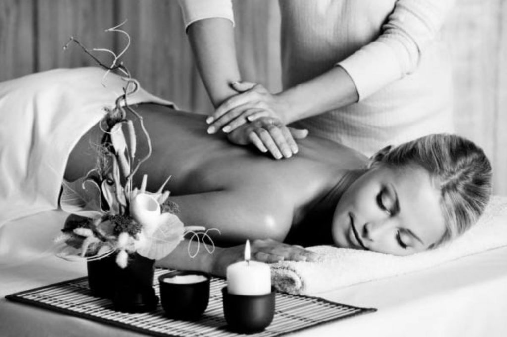 A woman receiving a relaxing back massage in a serene spa environment.
