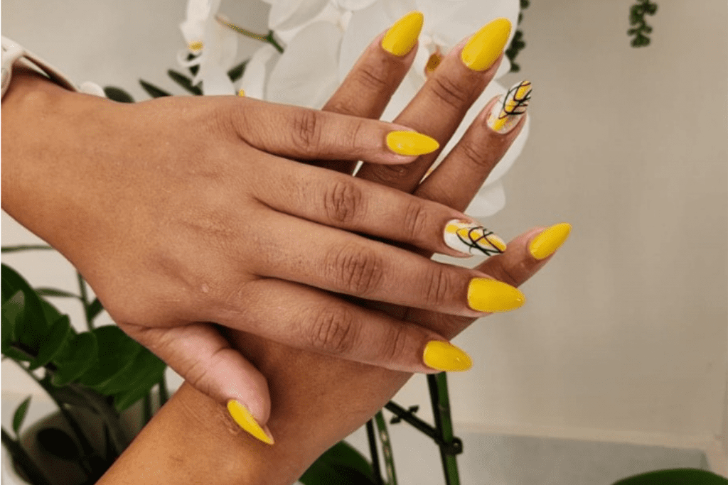 A woman showing off her yellow nails.