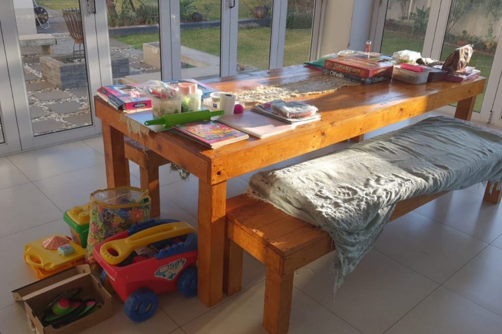 A wooden table displaying various toys and books, creating a playful and inviting atmosphere.