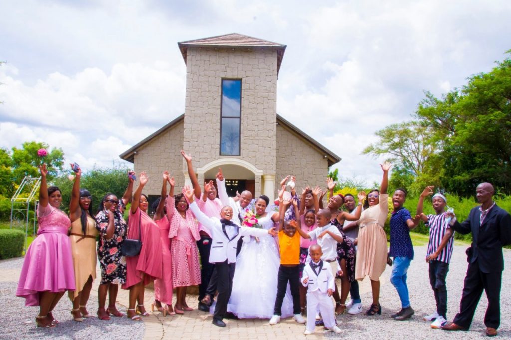 A group of people smiling and posing for a photo in front of a large church building.